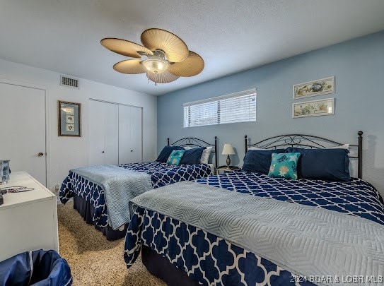 bedroom with a closet, ceiling fan, and carpet floors