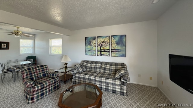 living room featuring ceiling fan, a textured ceiling, and carpet