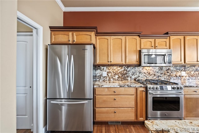 kitchen with light stone counters, backsplash, dark wood-type flooring, appliances with stainless steel finishes, and crown molding