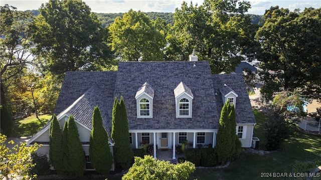 cape cod-style house with central AC and a front lawn