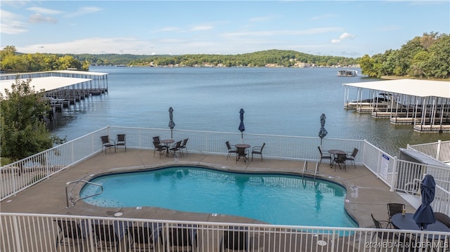 view of pool featuring a patio and a water view