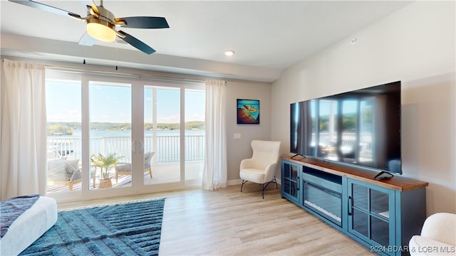 living room featuring ceiling fan, light hardwood / wood-style floors, and a wealth of natural light