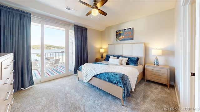 bedroom with a water view, ceiling fan, light colored carpet, and access to exterior