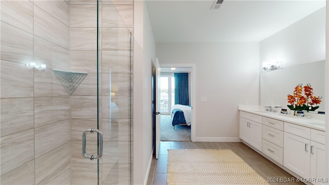 bathroom with hardwood / wood-style flooring, a shower with door, and vanity