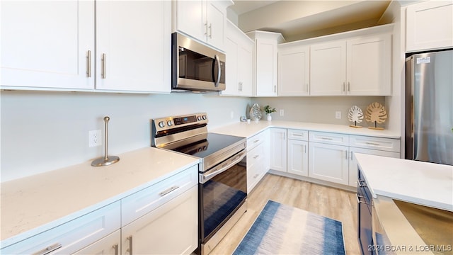 kitchen featuring light wood-type flooring, white cabinetry, and stainless steel appliances