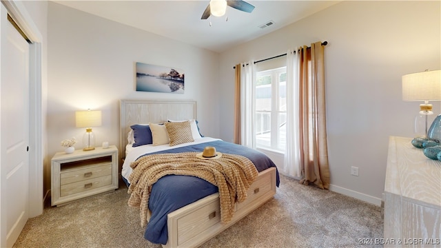 bedroom featuring light carpet, ceiling fan, and a closet