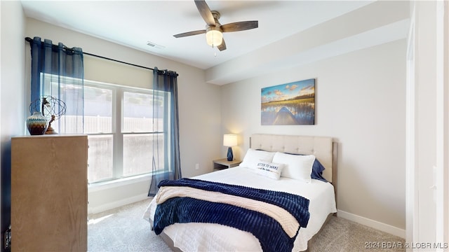 carpeted bedroom with ceiling fan and multiple windows