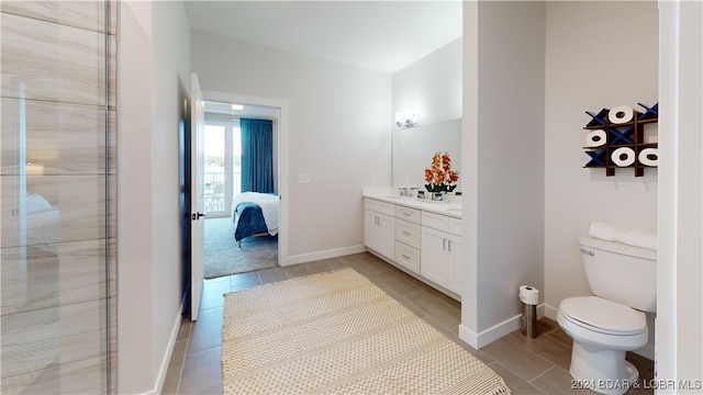 bathroom featuring a shower with door, vanity, and toilet