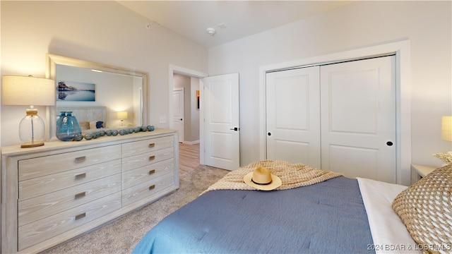 bedroom featuring light colored carpet and a closet