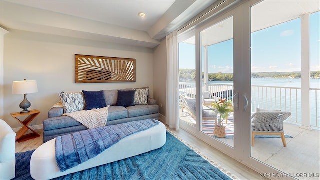 living room featuring light wood-type flooring and a water view