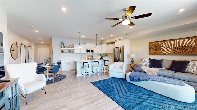 living room with light wood-type flooring and ceiling fan