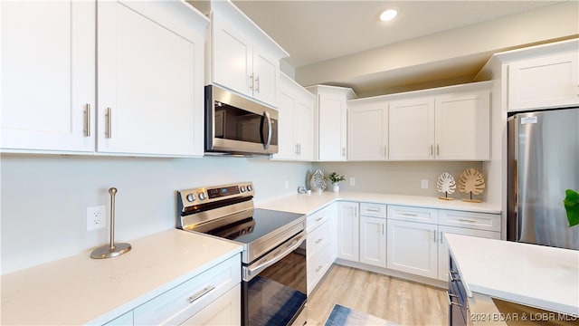 kitchen featuring light hardwood / wood-style flooring, white cabinetry, and appliances with stainless steel finishes