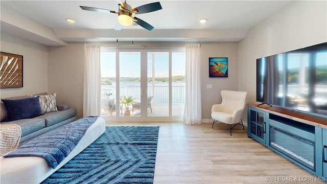 living room with light hardwood / wood-style floors and ceiling fan