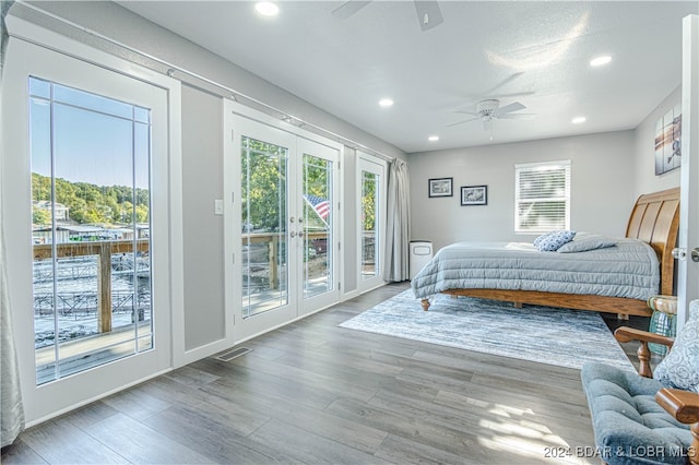 bedroom with access to outside, wood-type flooring, and ceiling fan