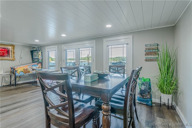 dining room featuring wood-type flooring, crown molding, and french doors