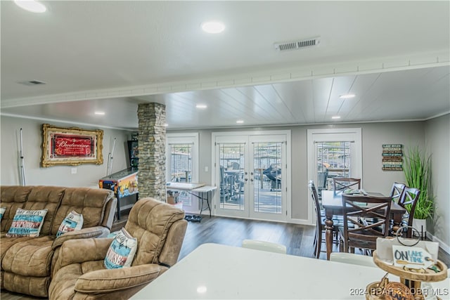 living room with dark hardwood / wood-style floors, decorative columns, and crown molding