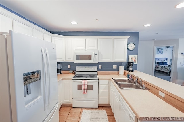 kitchen featuring light tile patterned flooring, sink, white cabinetry, kitchen peninsula, and white appliances