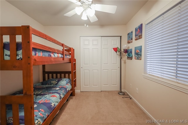 carpeted bedroom with multiple windows, ceiling fan, and a closet