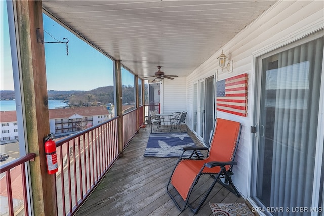 balcony featuring a water view and ceiling fan