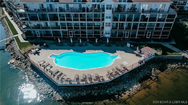 view of pool with a water view and a patio area