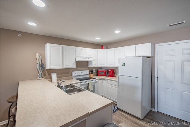 kitchen with white cabinets, white appliances, and a kitchen bar