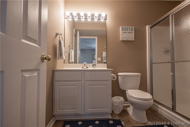 bathroom featuring vanity, toilet, an enclosed shower, and hardwood / wood-style flooring