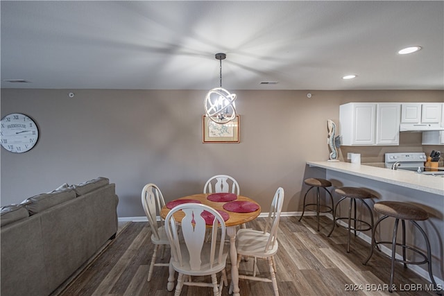 dining space with an inviting chandelier and dark hardwood / wood-style flooring