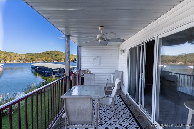 balcony featuring ceiling fan and a water view