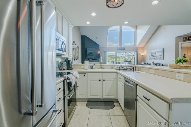 kitchen featuring light tile patterned floors, stainless steel appliances, sink, and white cabinetry