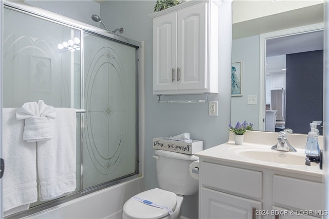 full bathroom with vanity, combined bath / shower with glass door, and toilet