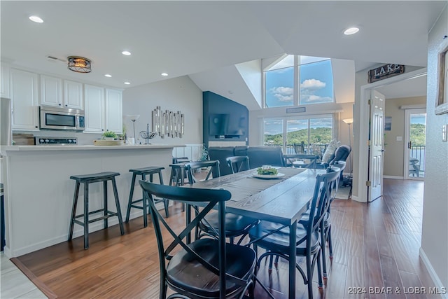 dining area featuring lofted ceiling and hardwood / wood-style flooring