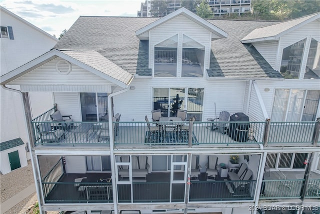 back of house featuring a balcony and outdoor lounge area