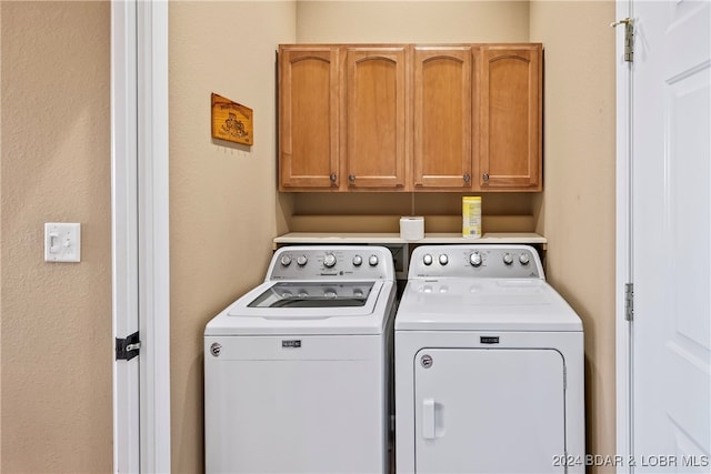 washroom featuring washer and dryer and cabinets