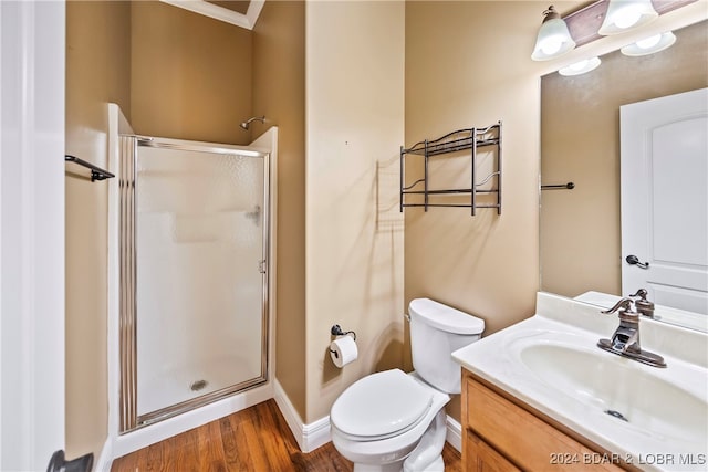 bathroom featuring wood-type flooring, vanity, toilet, and an enclosed shower