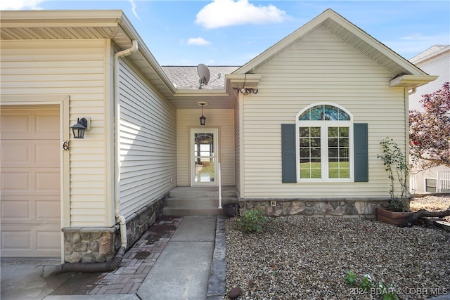 doorway to property with a garage