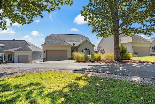 ranch-style house featuring a garage and a front lawn