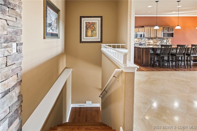 stairway with crown molding and hardwood / wood-style flooring