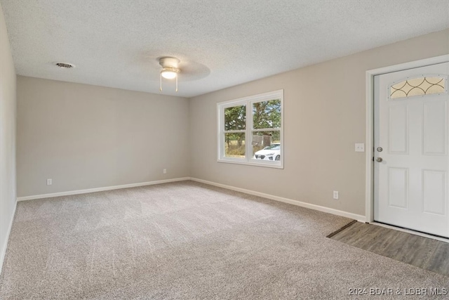 entryway featuring carpet floors, a textured ceiling, and ceiling fan