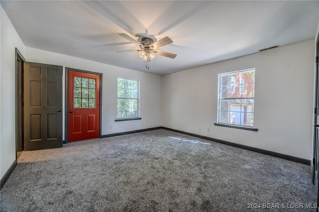 carpeted spare room featuring ceiling fan