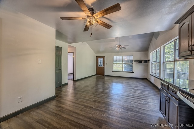 unfurnished living room with lofted ceiling, ceiling fan, dark wood-type flooring, and a textured ceiling