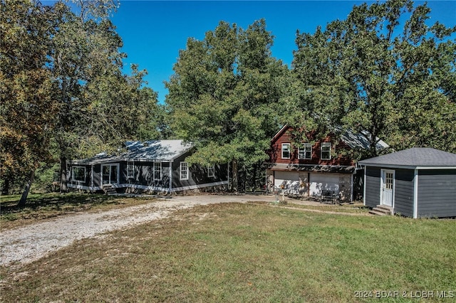 view of yard featuring a garage and a sunroom