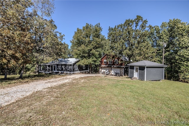 view of front of property featuring a storage shed and a front lawn