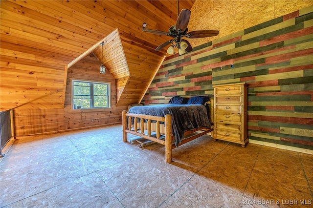 unfurnished bedroom with wooden walls, vaulted ceiling, and ceiling fan