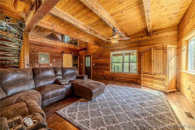 living room with wooden walls, wood ceiling, a barn door, and dark hardwood / wood-style flooring