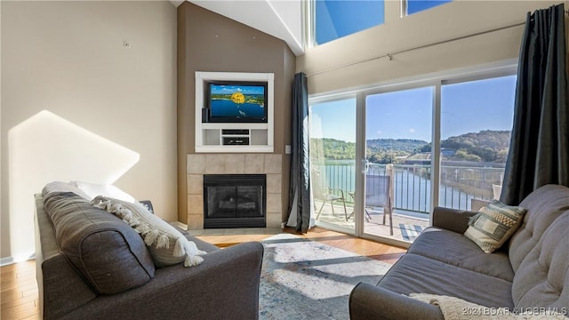 living area featuring a tiled fireplace and wood finished floors