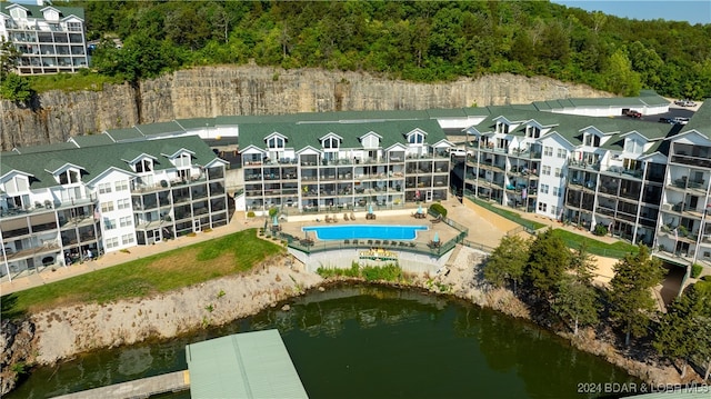 view of building exterior with a water view and a community pool