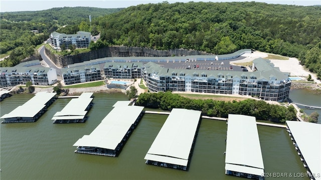 birds eye view of property featuring a water view and a forest view