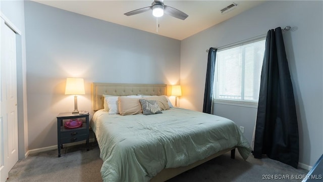 carpeted bedroom featuring a ceiling fan, visible vents, and baseboards