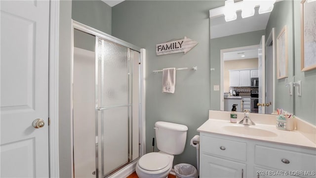 bathroom with a stall shower, vanity, and toilet