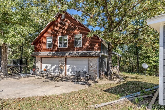 view of home's exterior with a lawn, a deck, and a garage